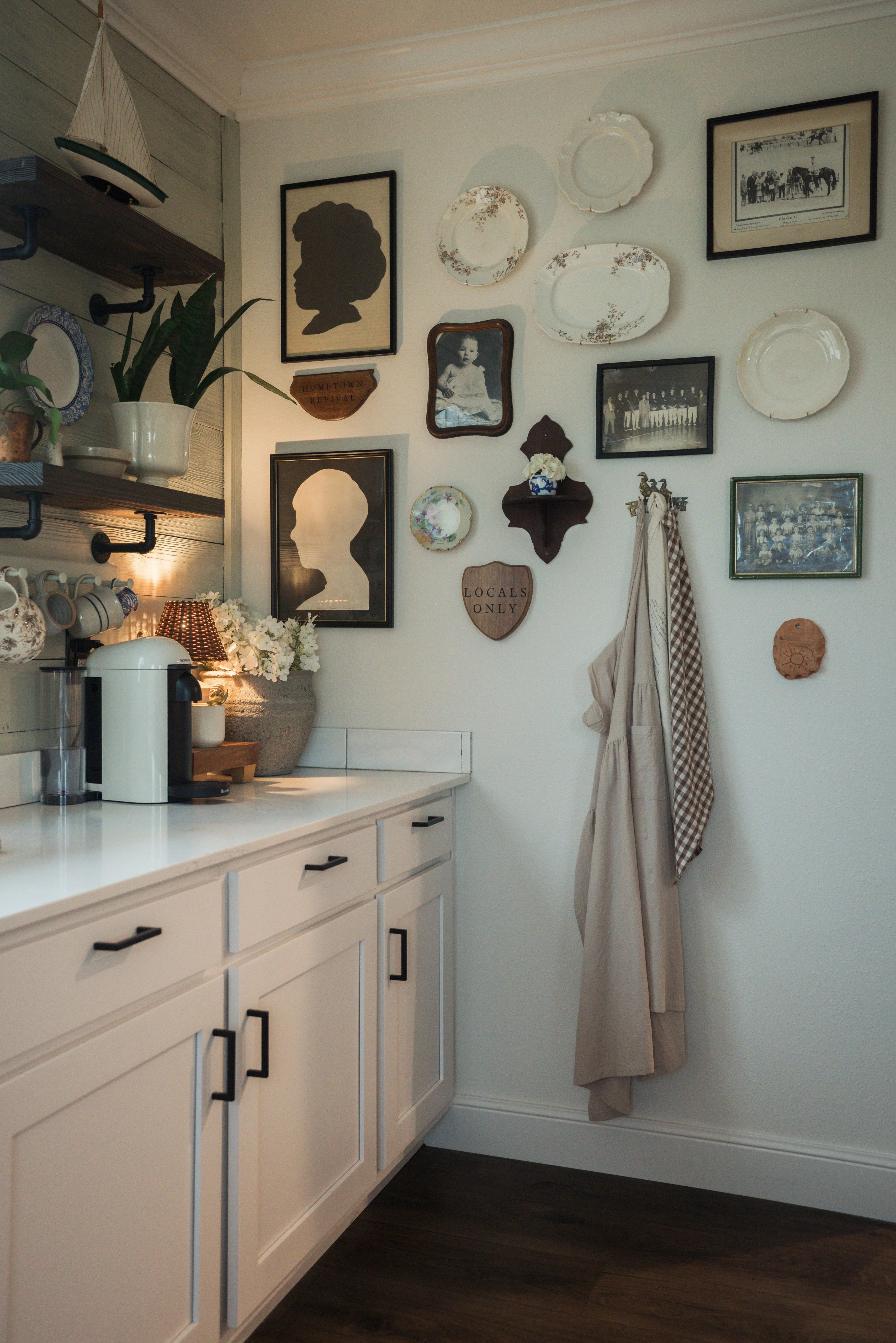 Koven’s antique collection of plates and portraits hanging on her kitchen wall.