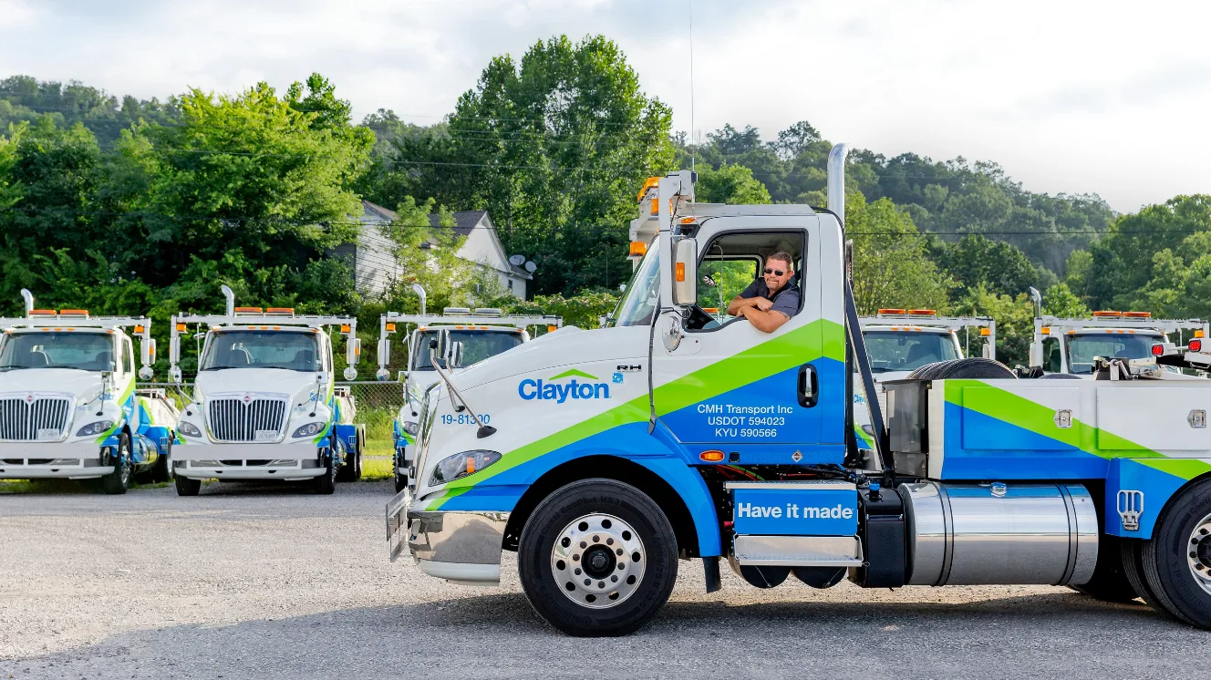 Man driving a Clayton truck used for housing transportation.