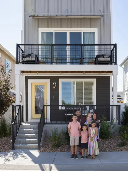 The  Cebreroses standing in front of black and beige two-story On2 home.