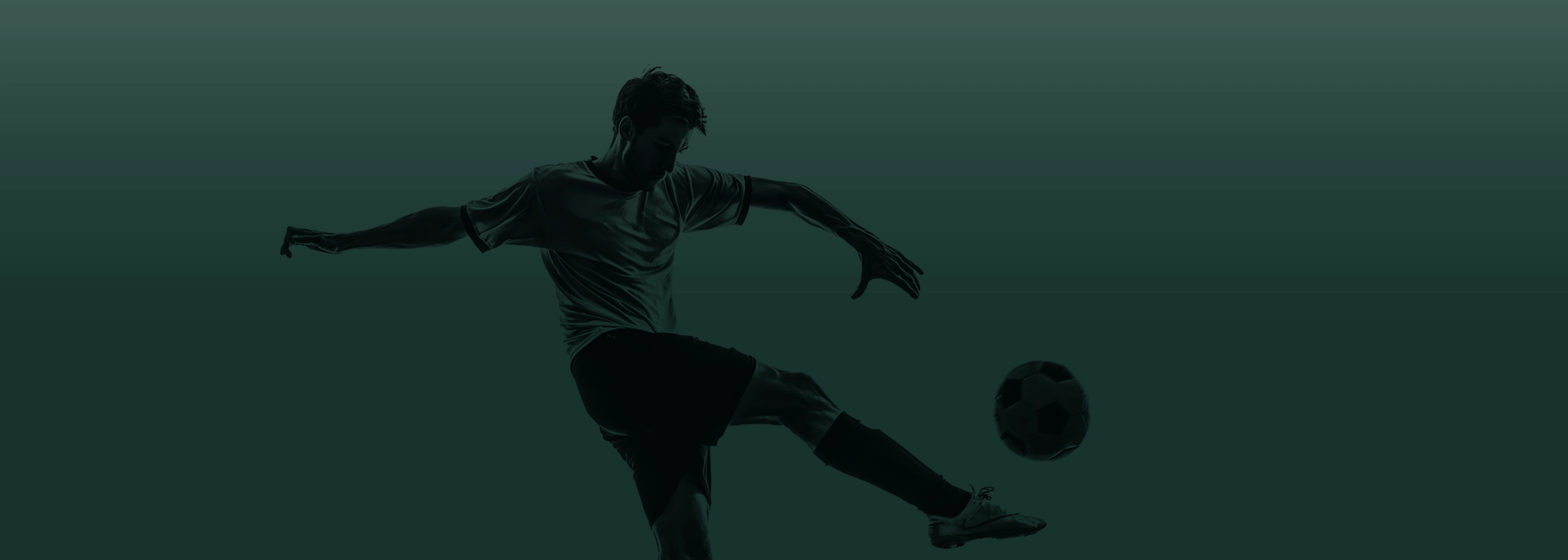 Man kicking a soccer ball.