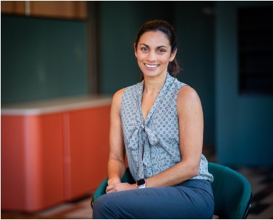 Dr Nienke Lees sitting on a chair and smiling at the camera.