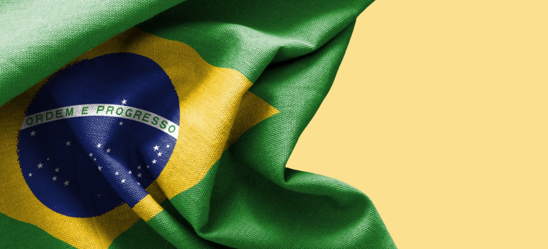 Brazilan flag against pale yellow background.