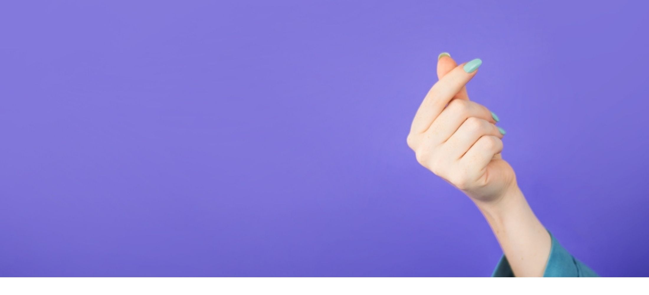Heart fingers against purple background