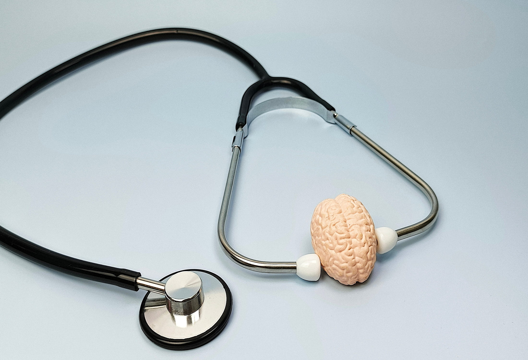 A stethoscope with a small model of a human brain attached to its tubing, symbolising neurology.