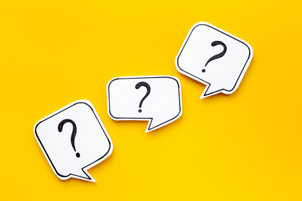 Three black and white paper cut-out question marks against bright yellow background.