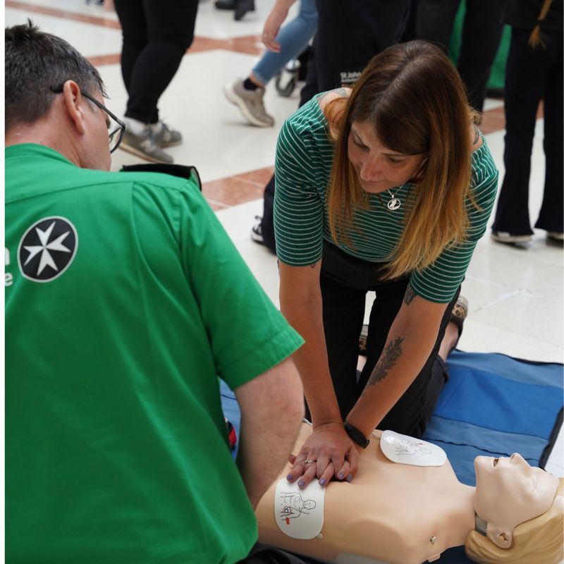St John Ambulance volunteers teaching students how to perform first aid.