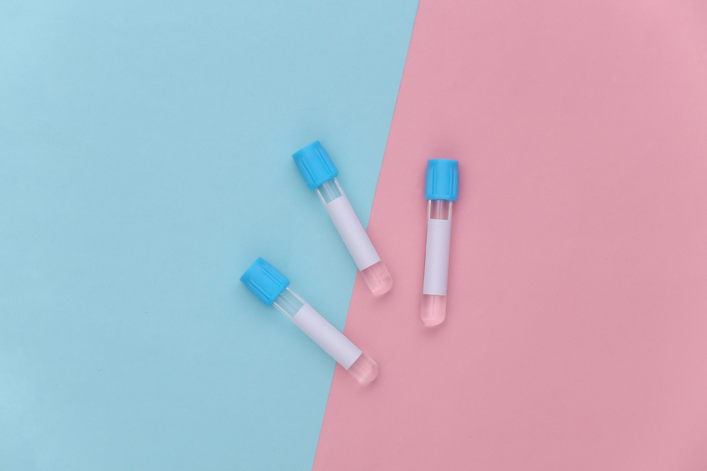 Empty medical test tubes against a blue and pink background.