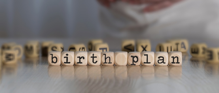 Words BIRTH PLAN composed of wooden letters. Pregnant woman in the background