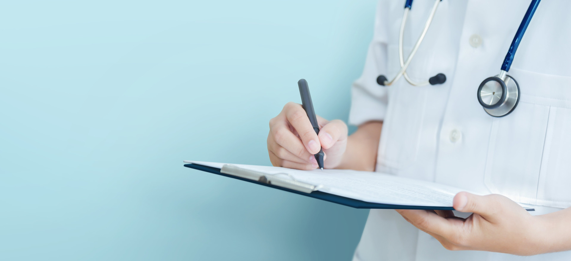 A close up of a doctor signing a fit note.