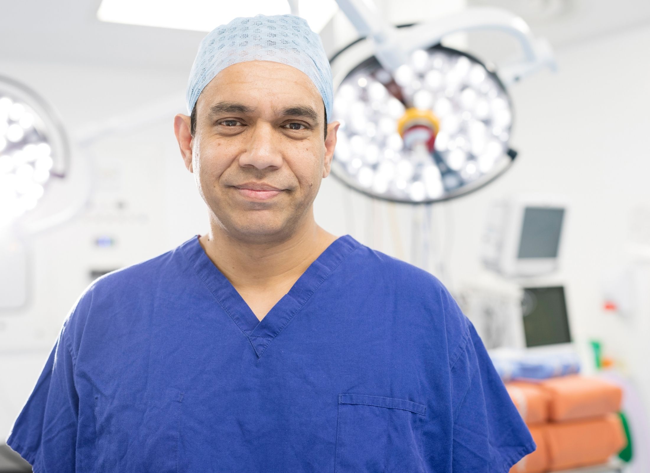 Photo of Dr Nurul Ahad wearing blue medical scrubs