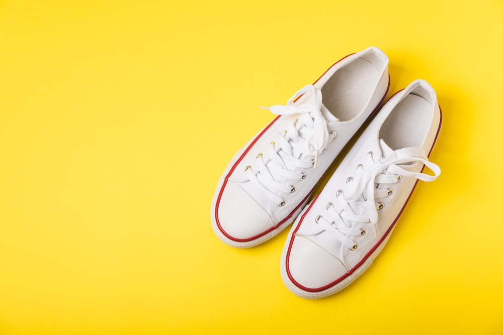 Red and white trainers against a bright yellow background.