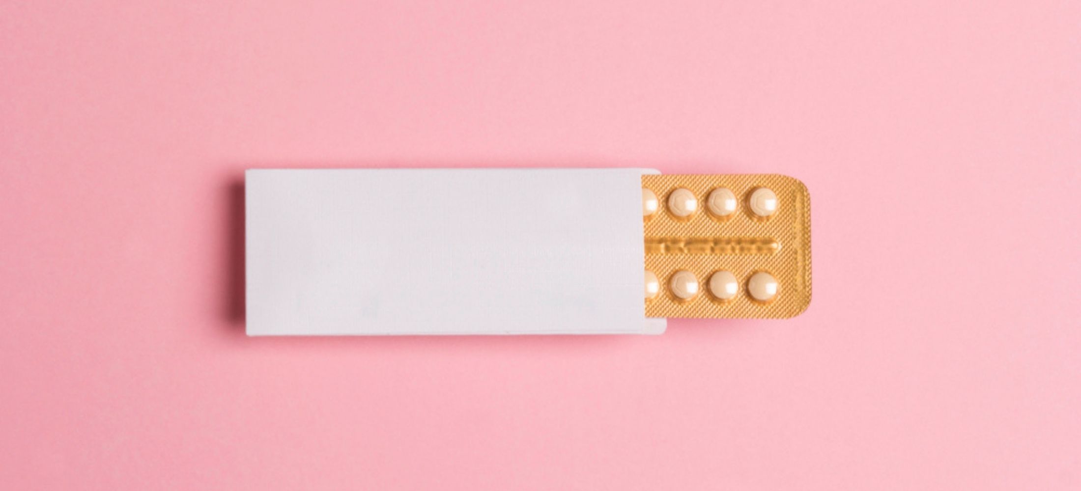 Female oral contraceptive pills blister on pink background.