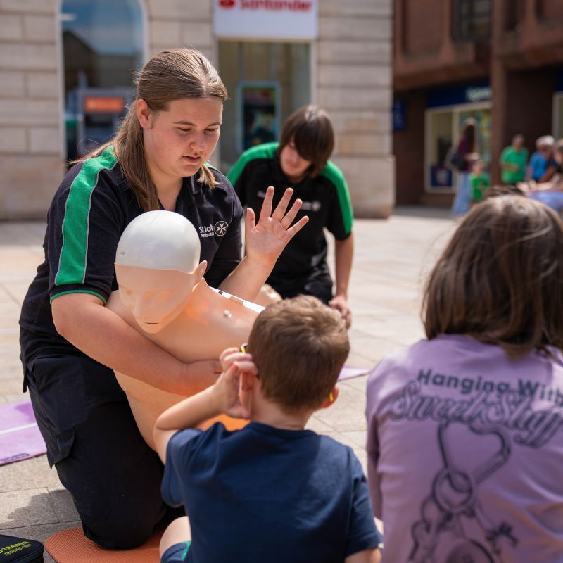 St John Ambulance volunteers teaching students first aid.
