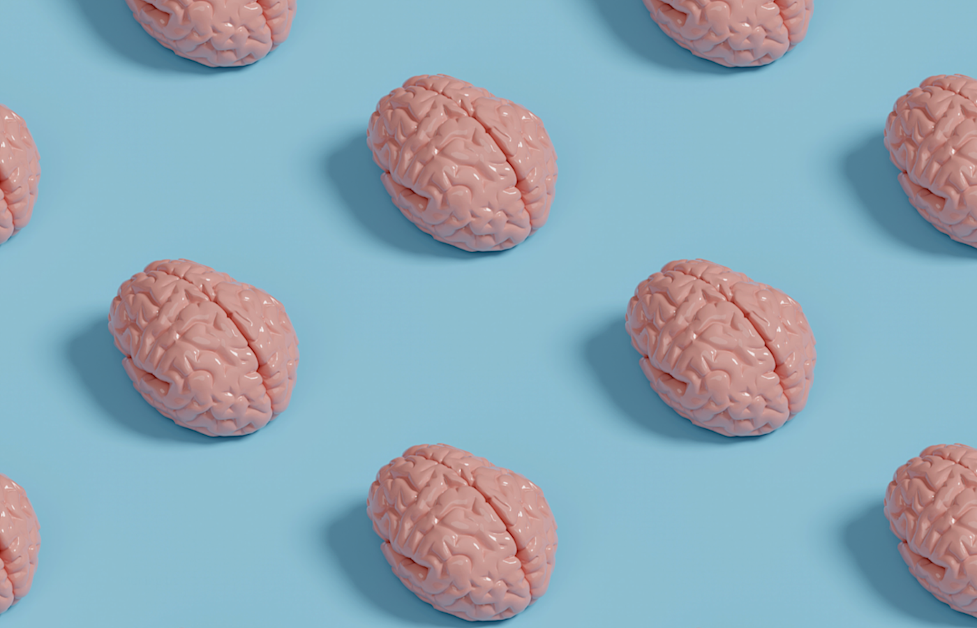 Pink plastic brain models arranged in a pattern on a light blue background, creating a modern, scientific aesthetic.