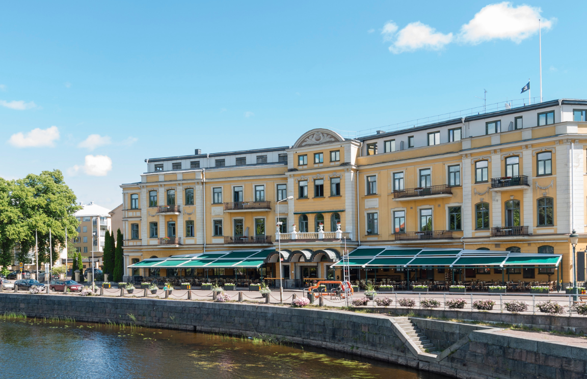 Gul fasad av Elite Stadshotellet i Karlstad med Klarälven framför
