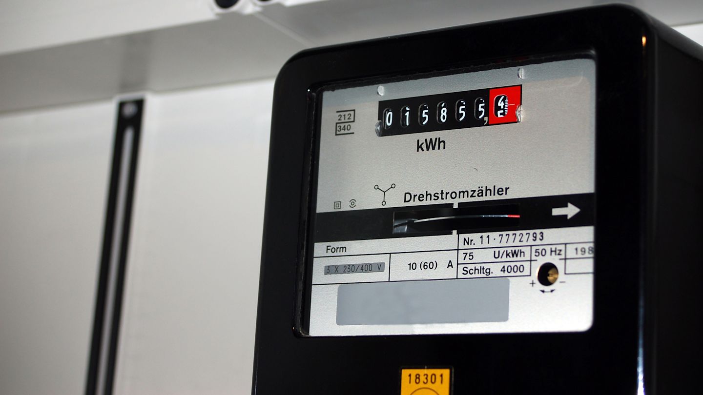 Nahaufnahme eines schwarzen, analogen Drehstromzählers mit sichtbarem Zählwerk.