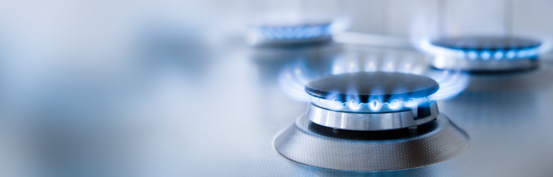 Brenner einer Gaskochplatte mit Flamme.