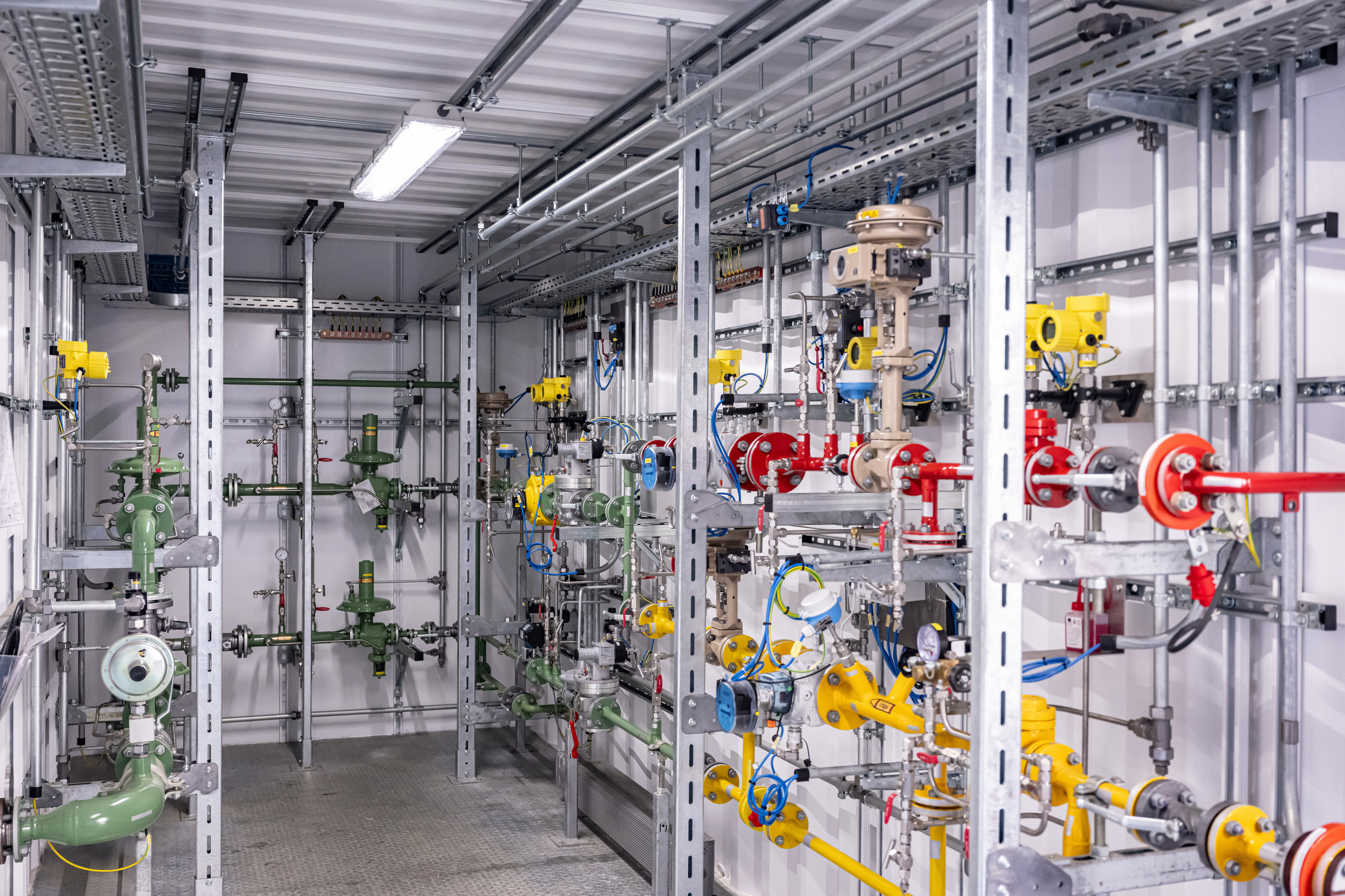 Darstellung des inneren Teils der Mischgasanlage. In rot sieht man die Wasserstoffstrecke, in gelb die Erdgasstrecke und in grün hinten rechts die Mischgasstrecke. Die grünen Leitungen an der hinteren Wand und links sind Gasdruckregelstrecken.