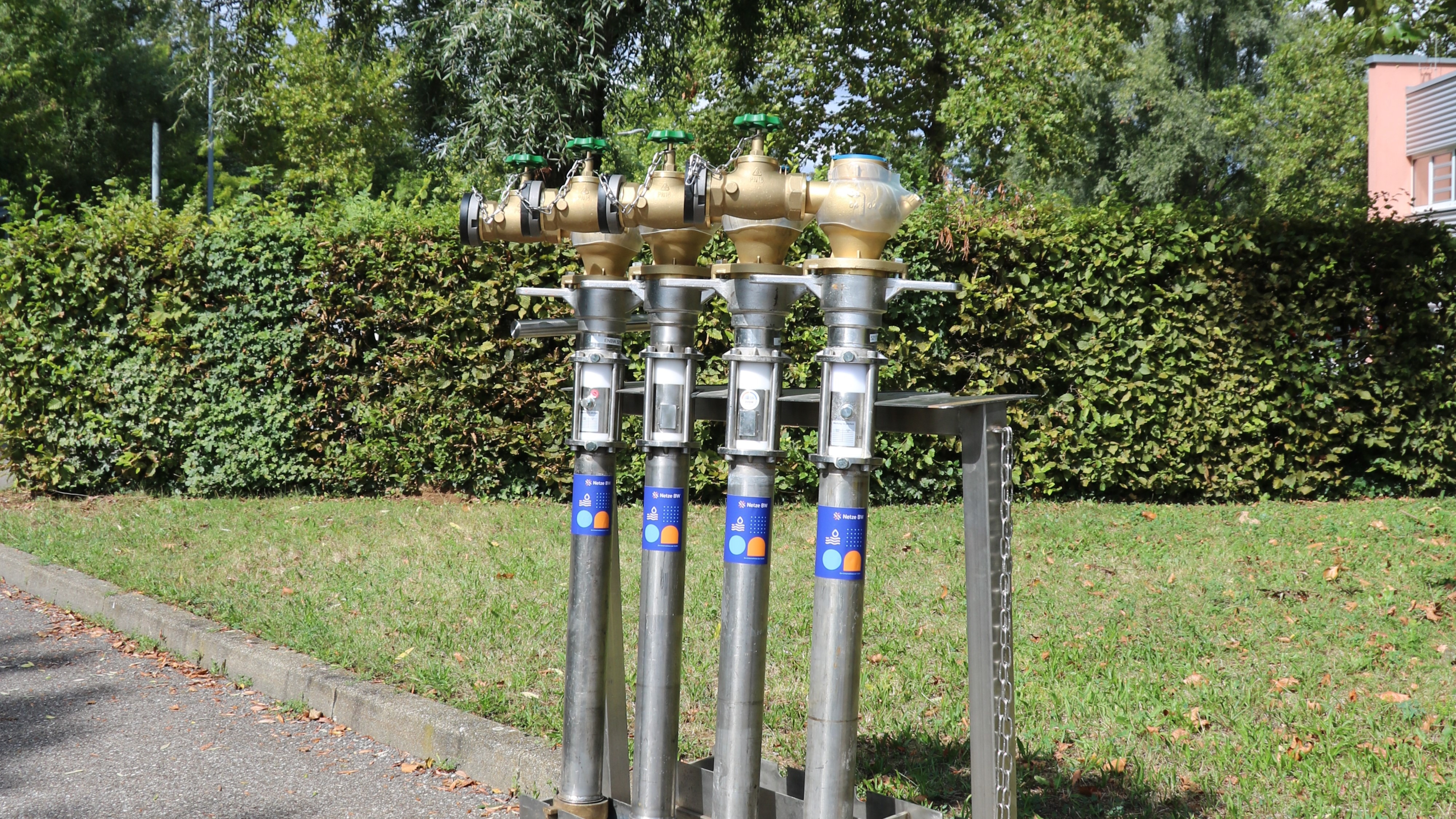 Vier Wasserzähler auf Gestell im Freien.