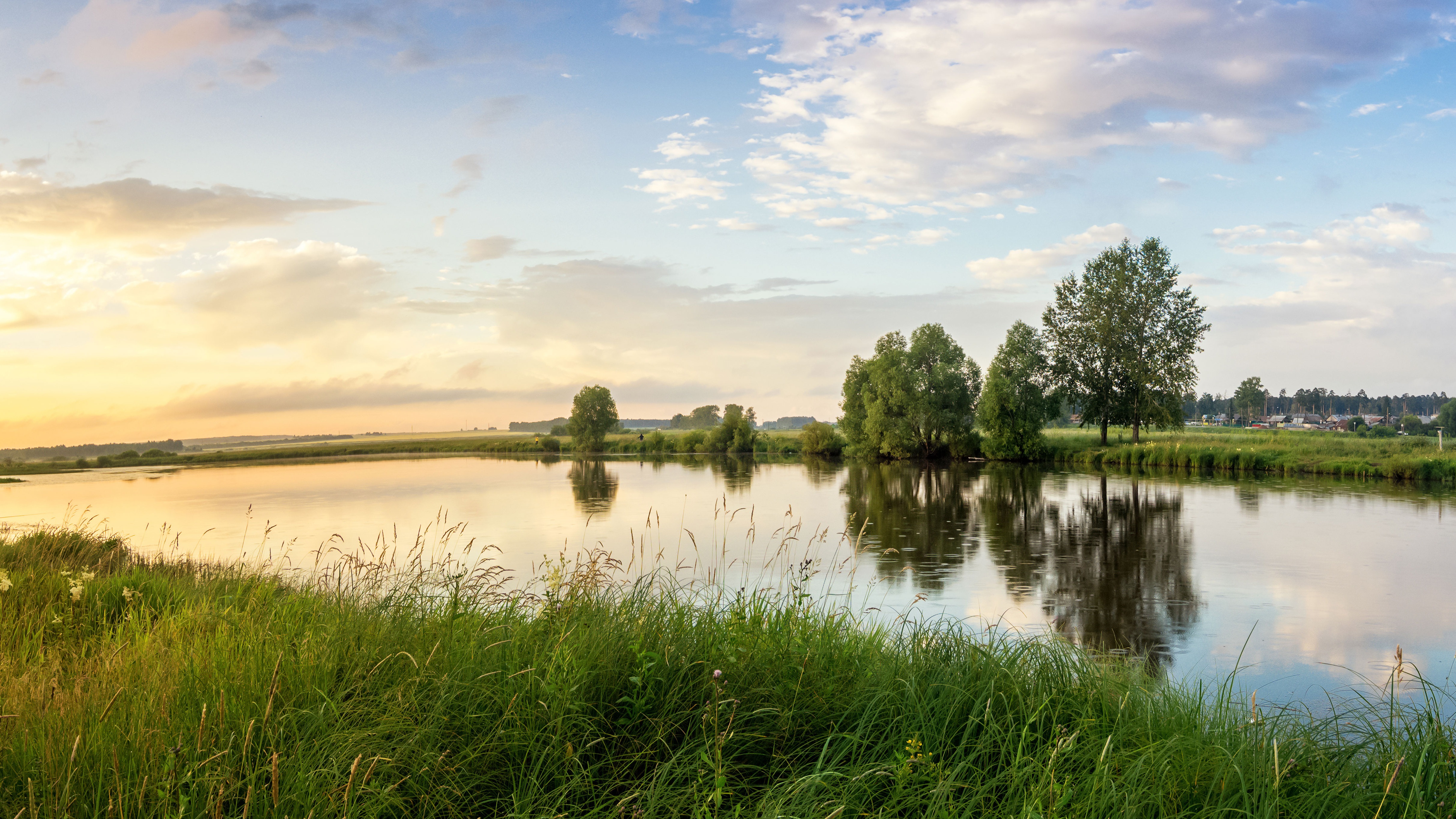 Landschaft mit einem Fluss und Bäumen mit Sonnenuntergang.