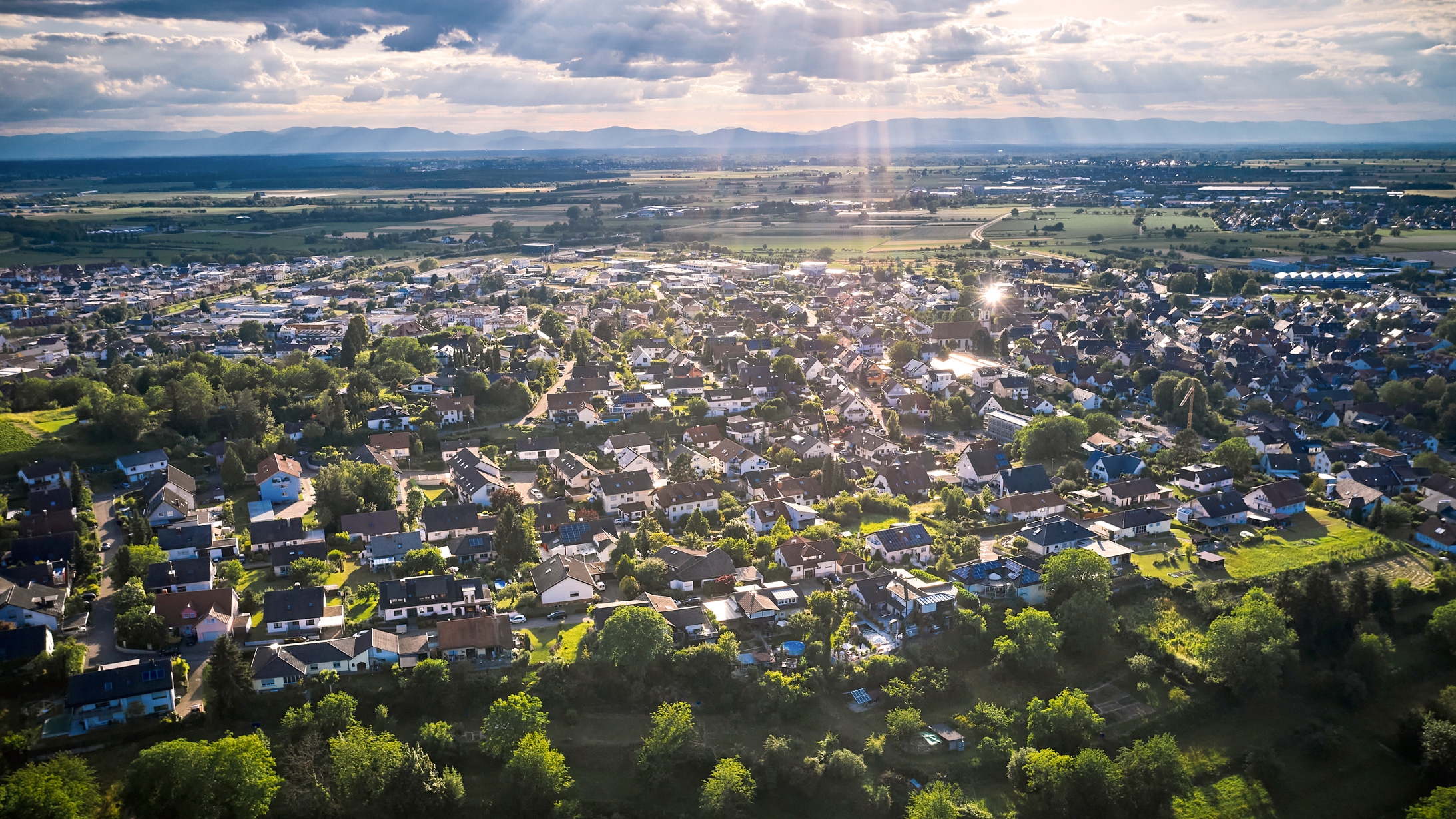 Sonnenbeschienene Wohnsiedlung aus der Vogelperspektive.