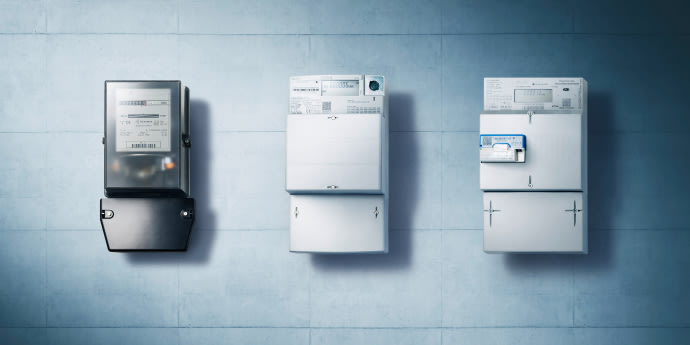 Drei moderne, elektronische Stromzähler an einer hellgrauen Wand montiert, daneben eine blaue Fläche mit Text zum Zählereinbau.