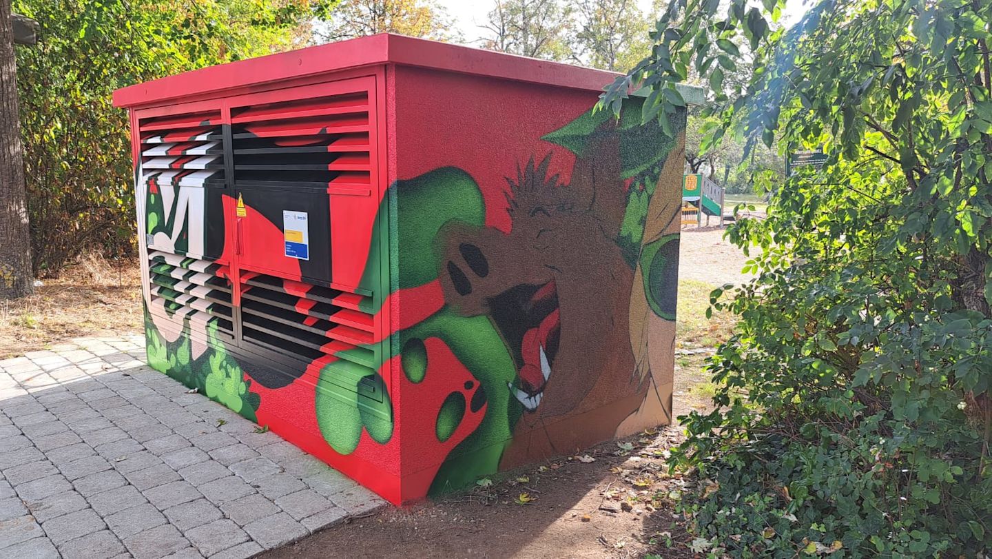 Graffiti an einer Trafostation: roter Hintergrund, braunes Warzenschwein.