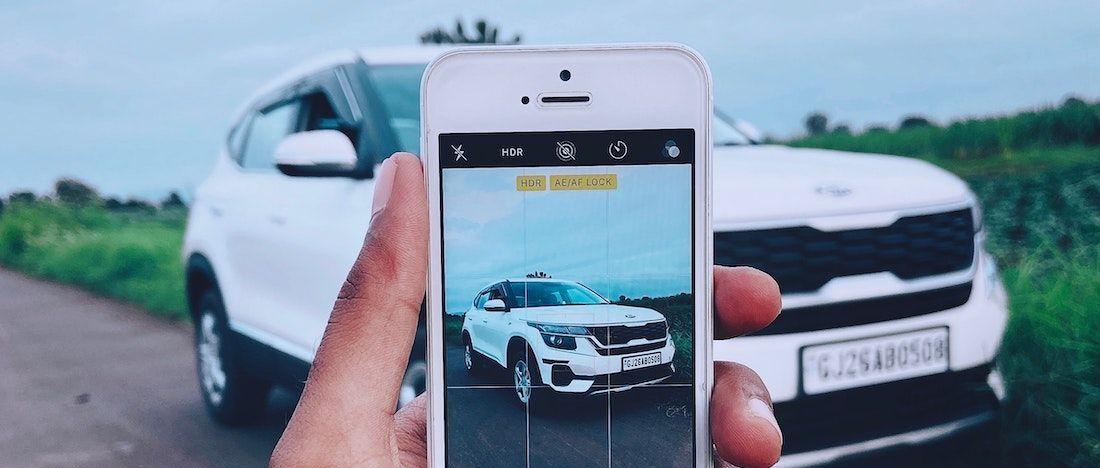 Téléphone portable prenant une photo d'une voiture