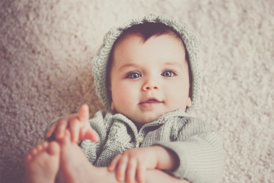 Glad bebis med stickade kläder