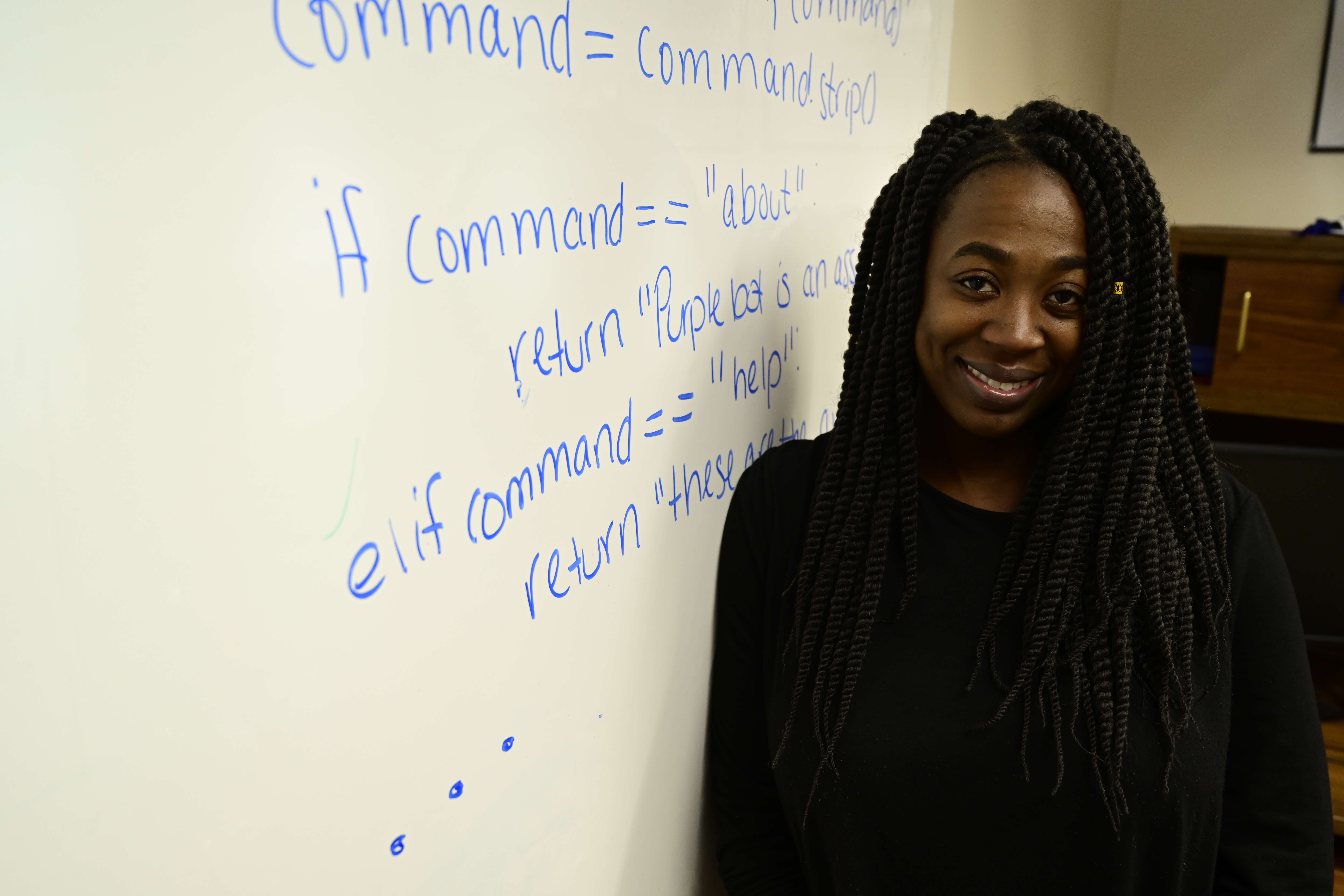 Student writing programming language on whiteboard