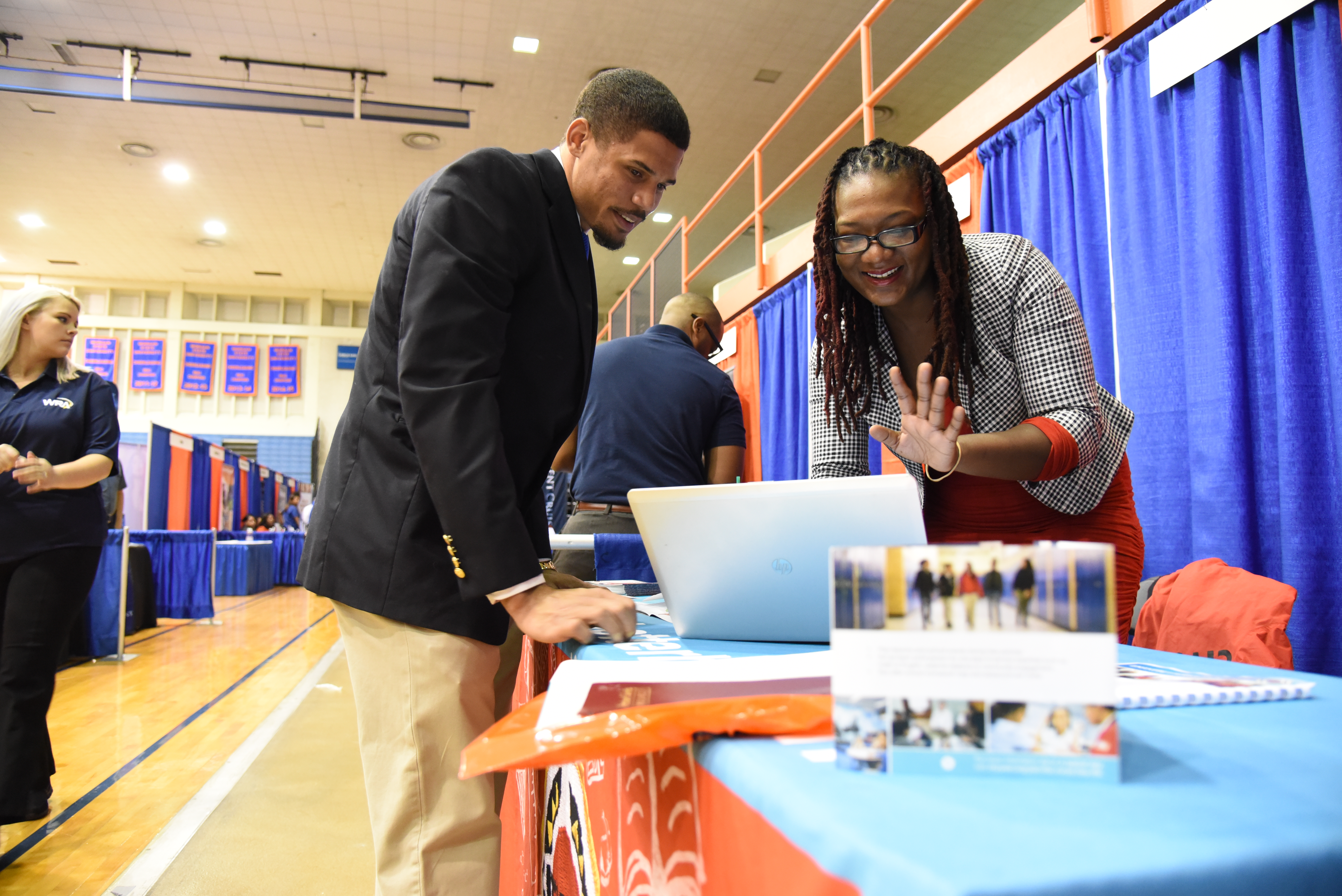 students working on laptop at career fair