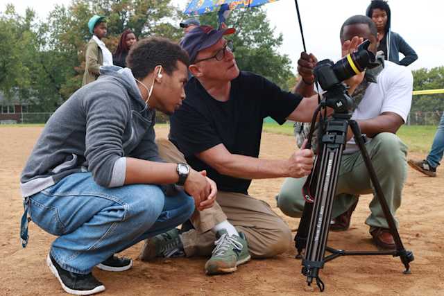 students and professor filming outside