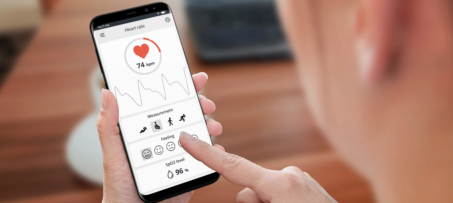 Person using a smartphone app displaying heart rate, SPO2 level, and relaxation icons, illustrating a stress and mental relaxation app designed to monitor wellness and promote calmness
