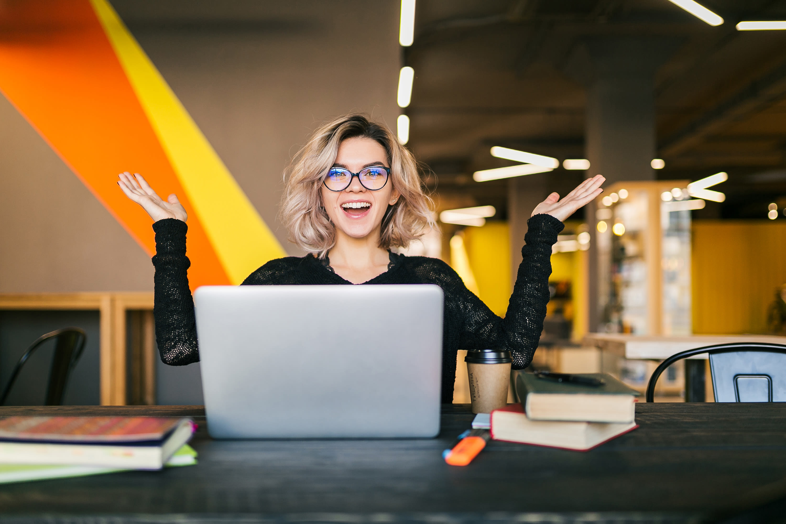 funny-happy-excited-young-pretty-woman-sitting-table-black-shirt-working-laptop-co-working-office-wearing-glasses2