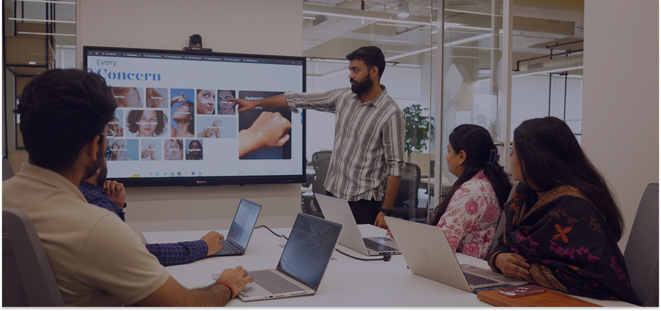 Digitup team in a meeting room discussing ideas with a screen presentation, reflecting their core values of trust, transparency, and collaboration