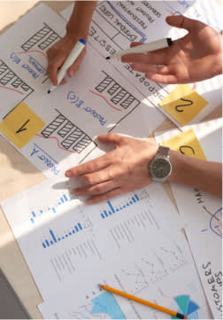 discussing design layouts and research charts on a table