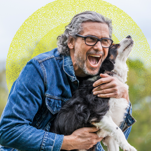 Hombre maduro sonriente abrazando a su perro, mientras reflexiona con tranquilidad sobre cómo ha construido su futuro gracias a +Protección