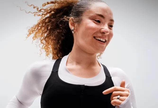 A woman smiling while running.