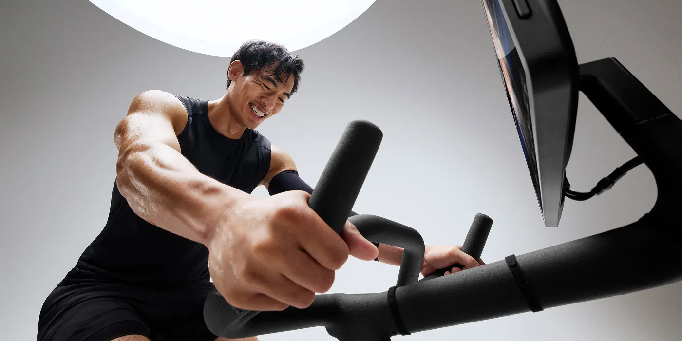 A male exerciser taking a cycling class on a Peloton Bike+ Pro