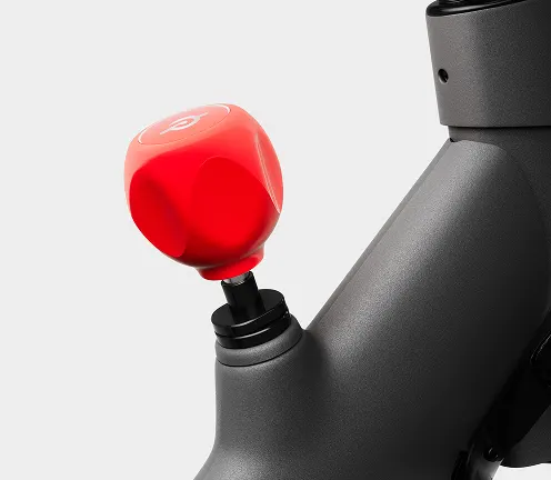 Peloton Bike+ with a large touchscreen display, red auto-resistance knob, and sleek black and gray frame