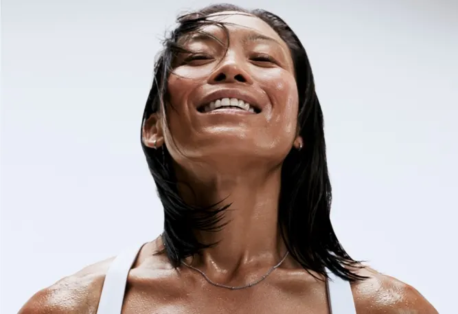 A woman sweating, but relieved after a workout.