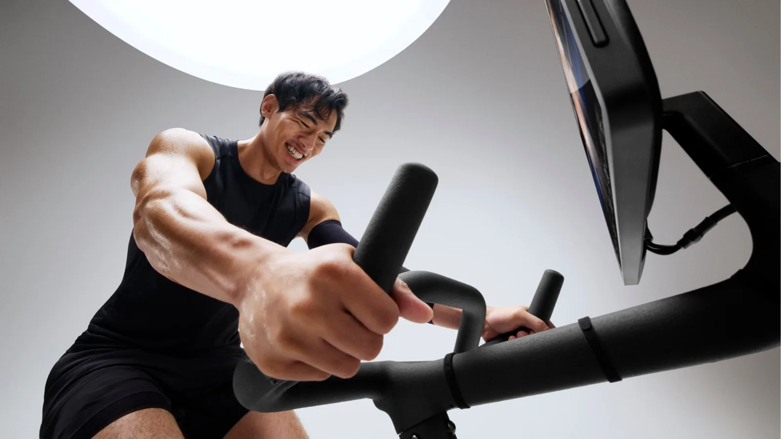 A male exerciser is working out on a Peloton Bike+ Pro 