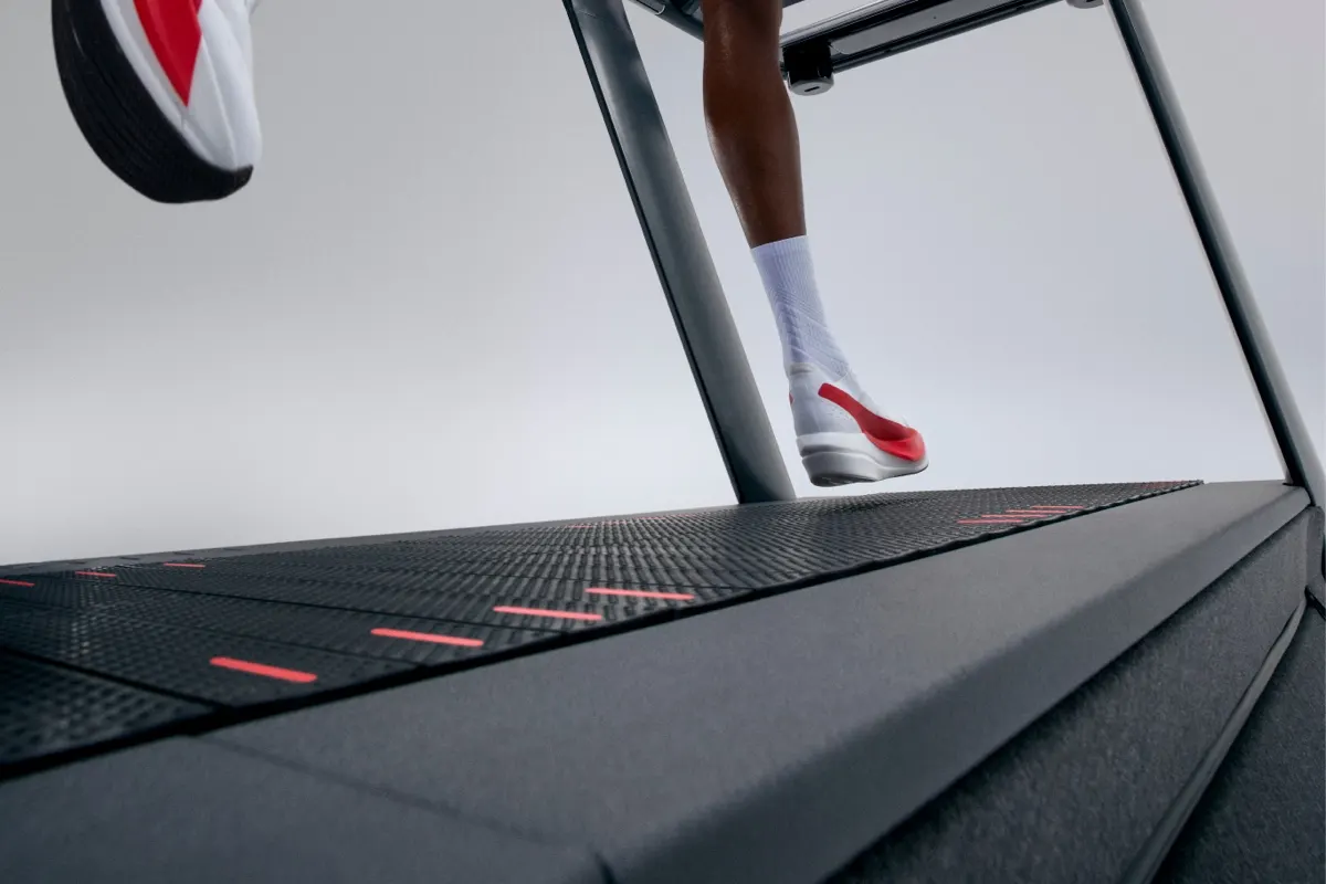Close-up of someone's sneakers as they run on the surface of Peloton Tread+ Pro.