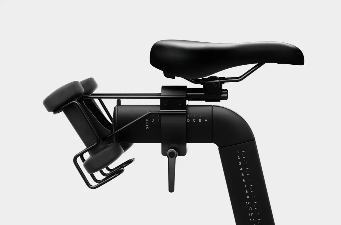The Peloton Bike seat showcasing the adjustment feature and weights on the back.