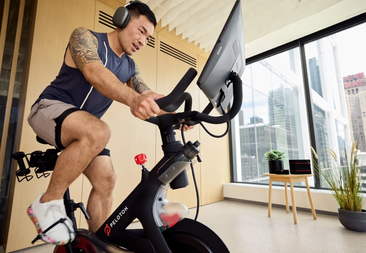 Apartment resident using a Peloton bike in the fitness facility