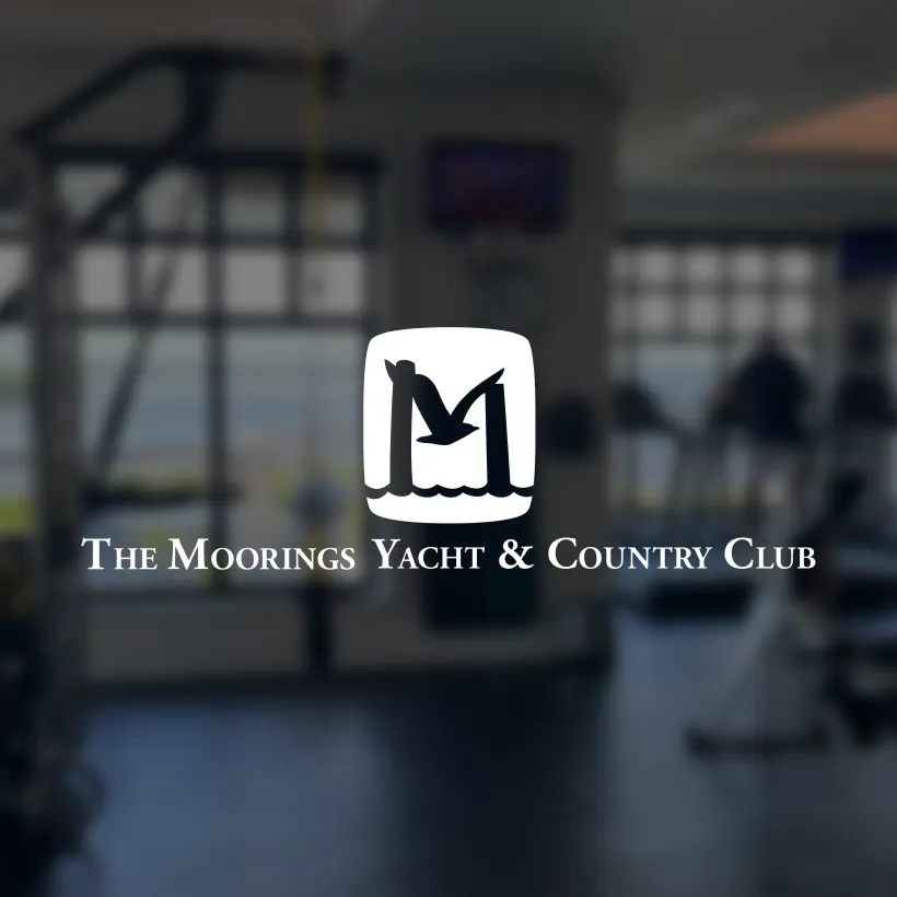 The logo for The Moorings Yacht and Country Club on top of a blurry background.