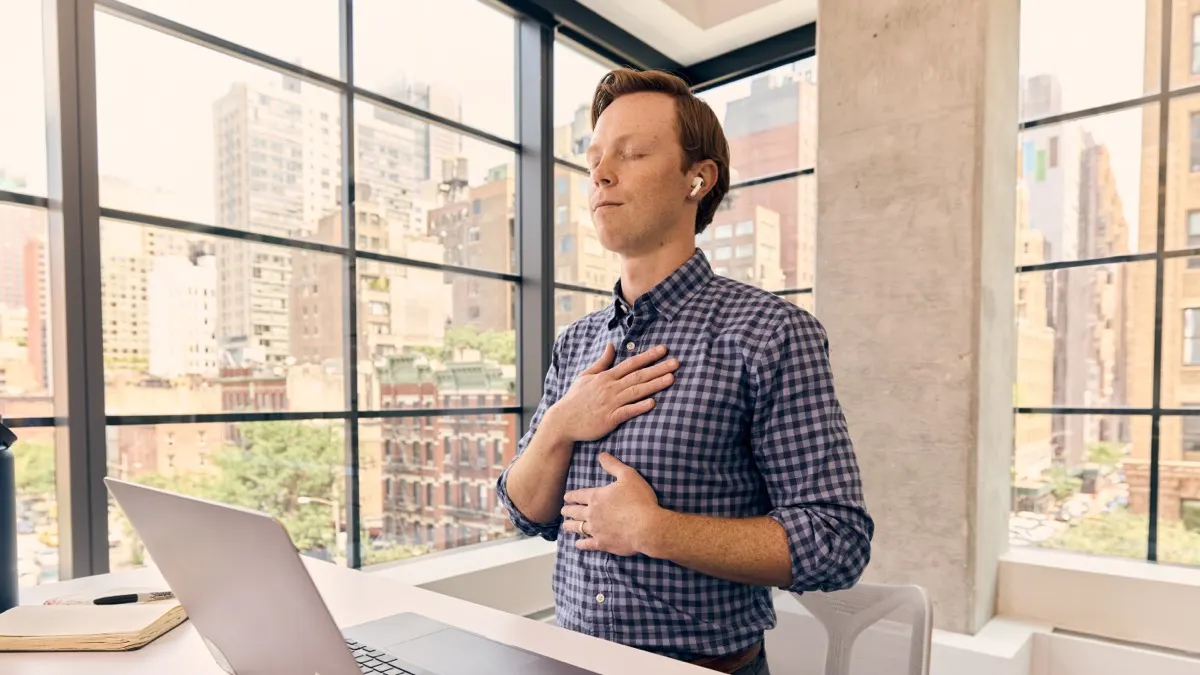 A Peloton member taking a meditation class at his desk