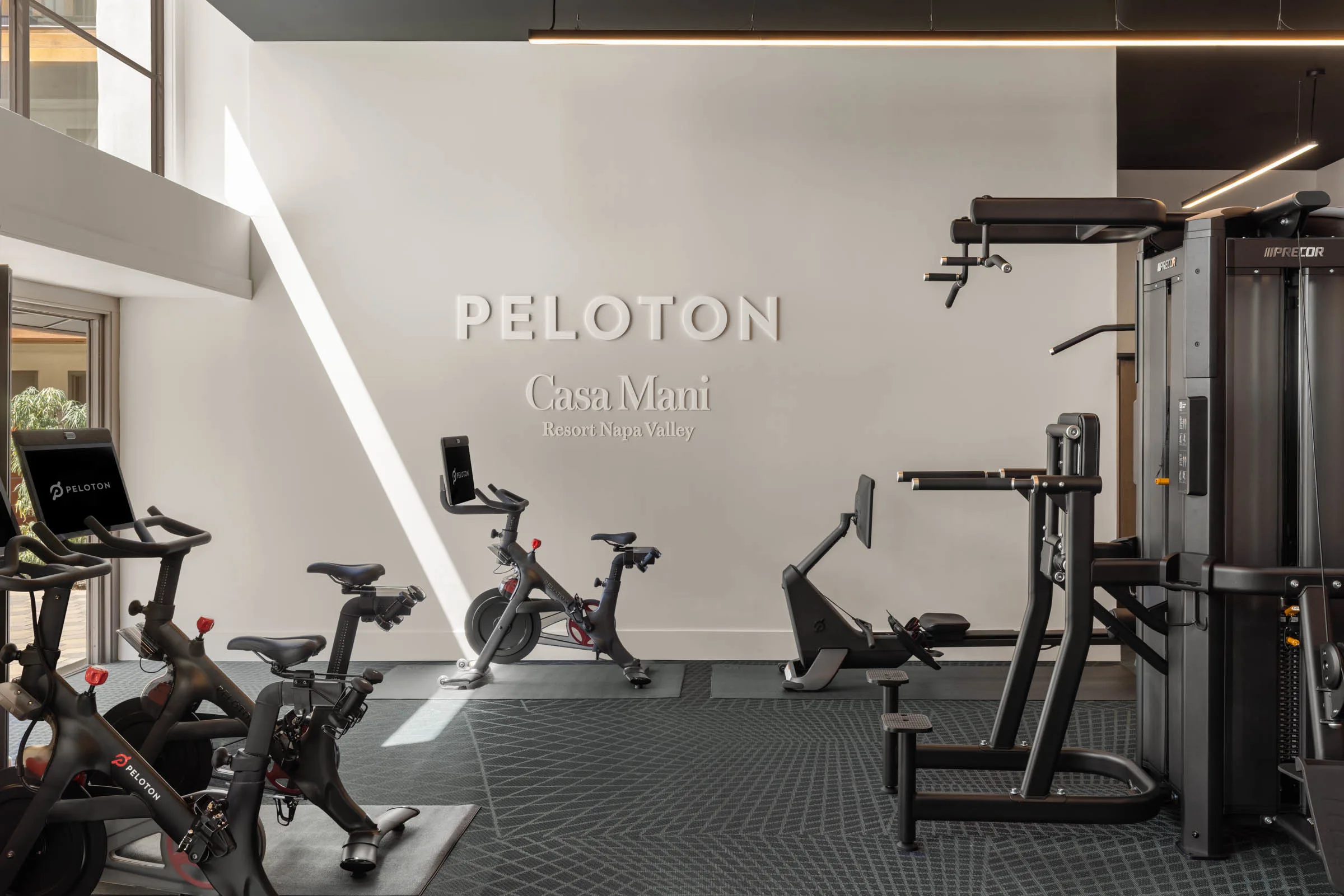 A Peloton branded gym featuring Peloton Bikes and Precor strength equipment