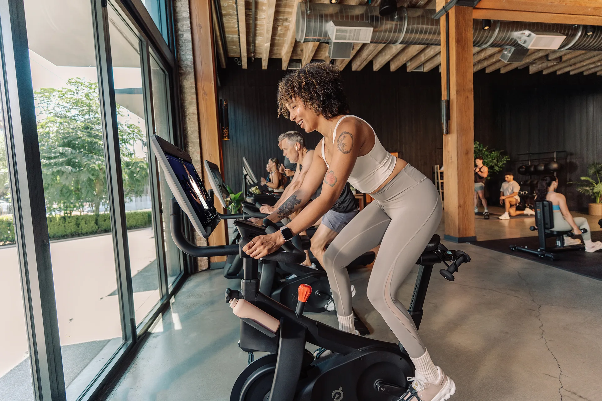 Eine Gruppe von Trainierenden auf Peloton-Commercial-Bikes in einem Fitnessstudio