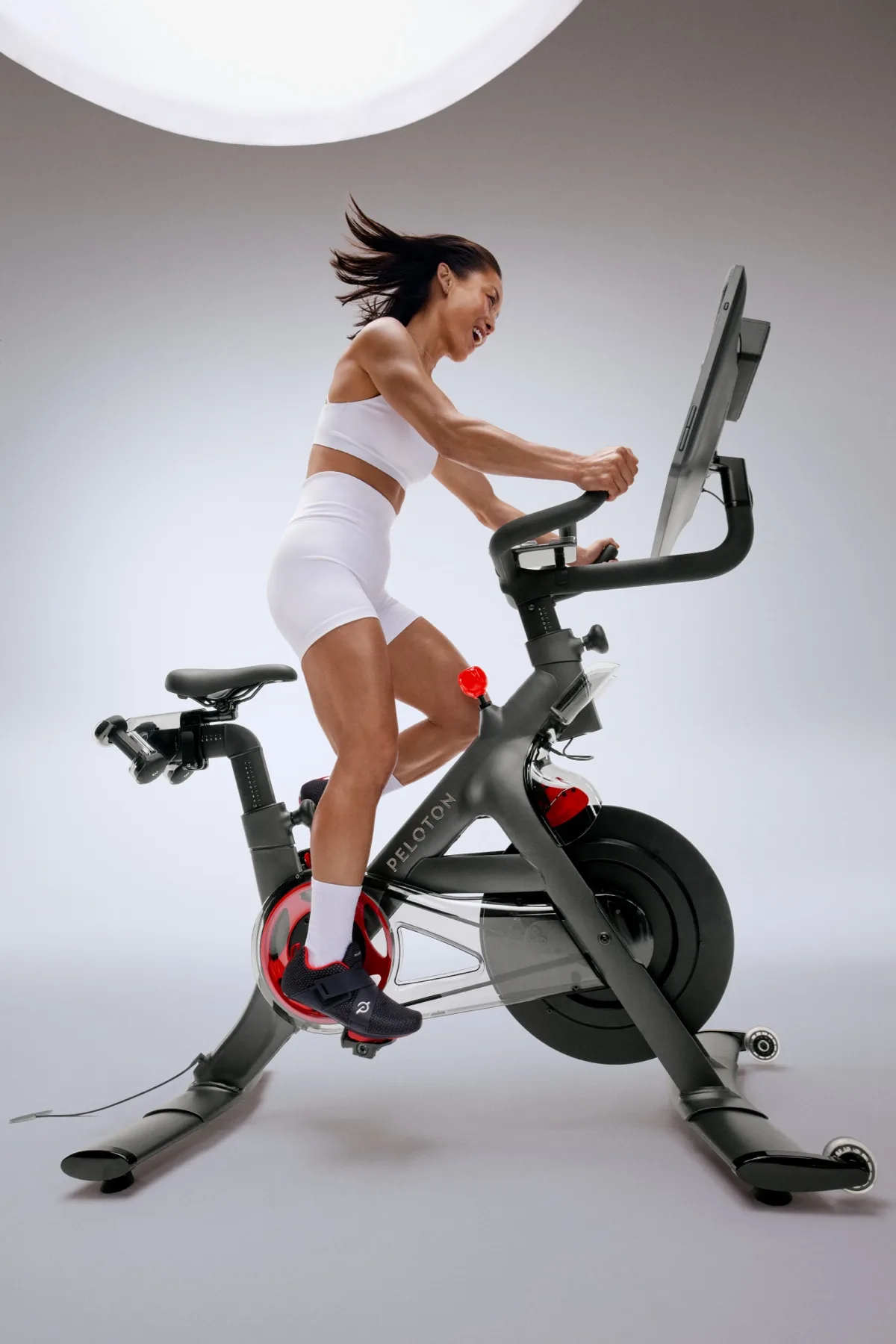 A female exerciser using a cross-functional Peloton Bike+ Pro